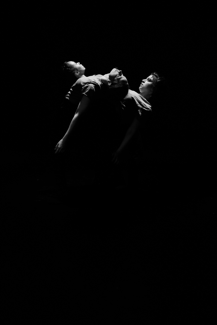 Actors performing together in darkness